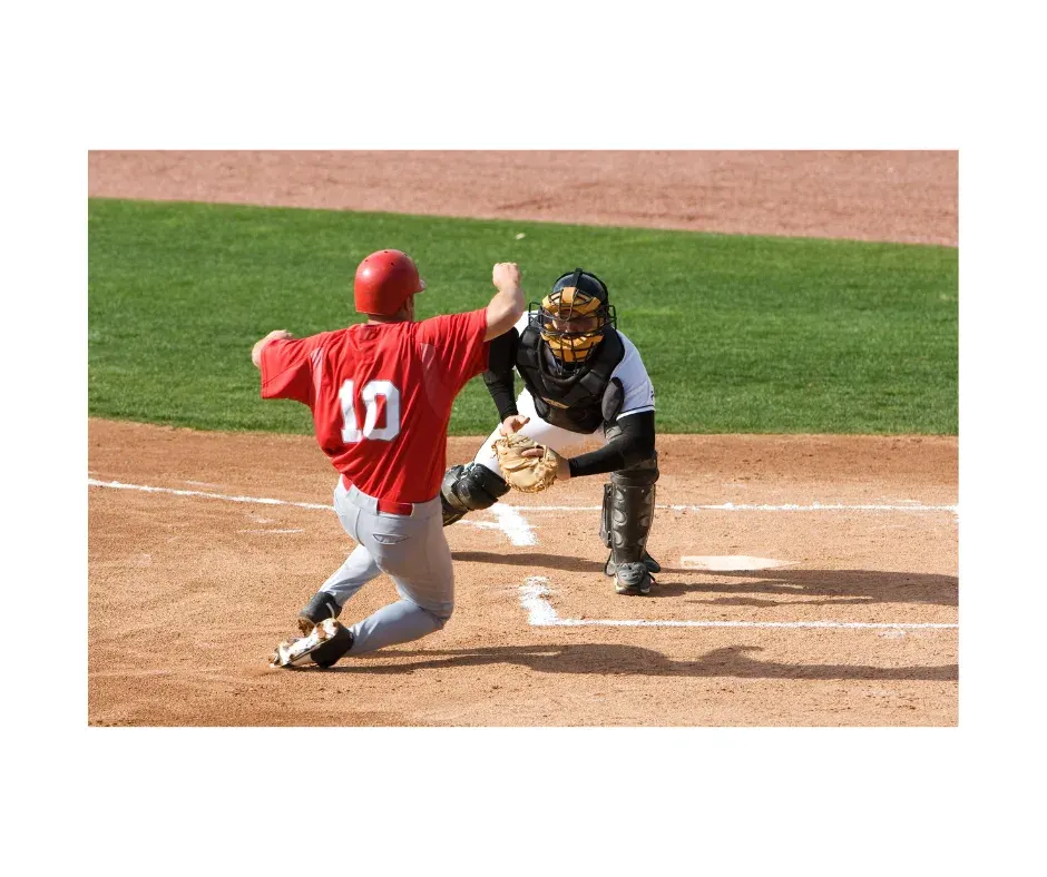 Baseball slide at home plate — dynamic play highlighting injury risk and compensation patterns